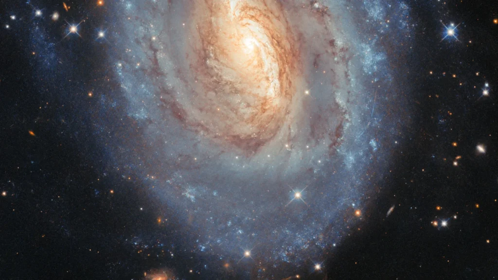 Hubble capta uma galáxia que brilha em azul e dourado