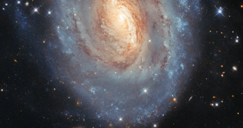 Hubble capta uma galáxia que brilha em azul e dourado