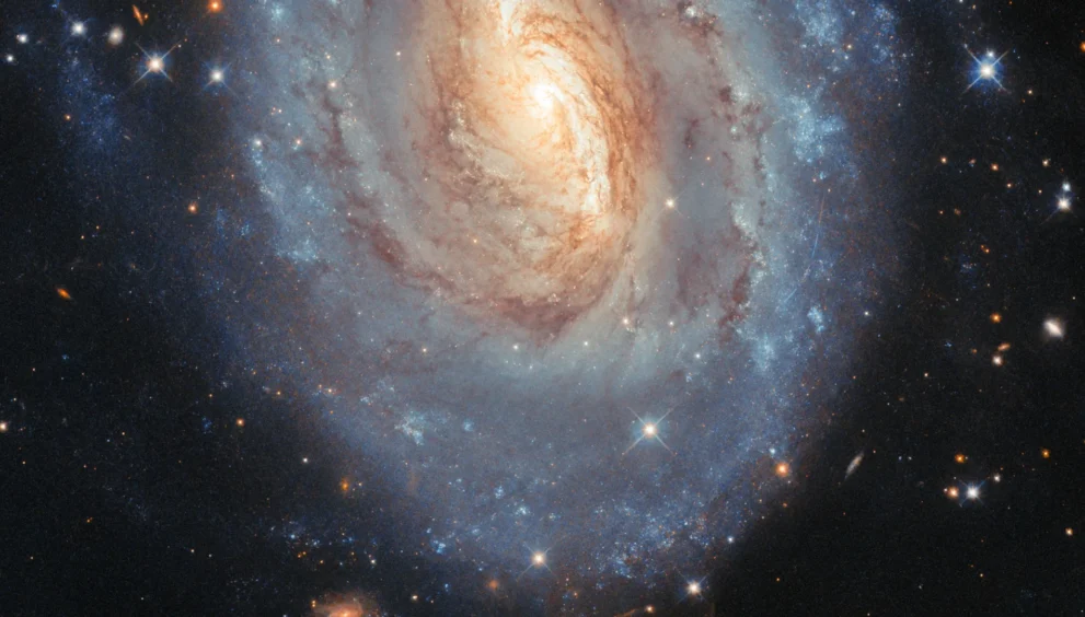 Hubble capta uma galáxia que brilha em azul e dourado